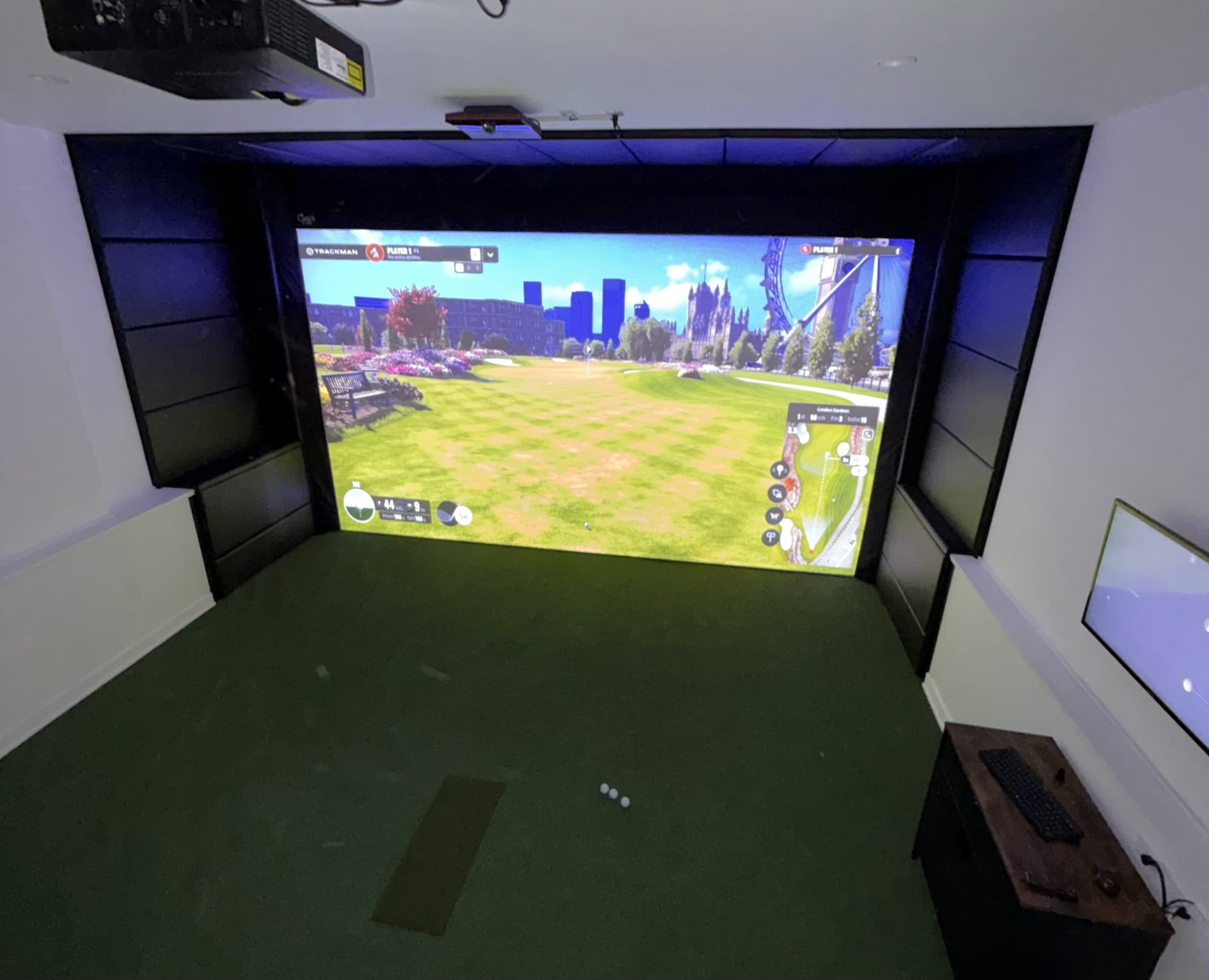 Golf simulator room framed floor to ceiling with black vinyl impact protection panels